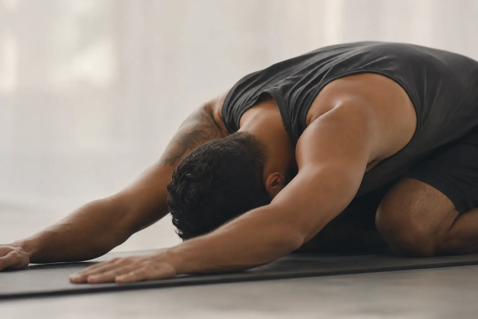A student resting in child's pose on a mat